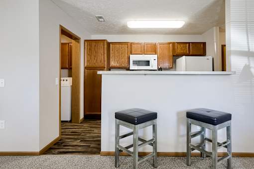 Two stools are in front of a white counter.