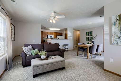 A living room with a grey couch and a grey ottoman.