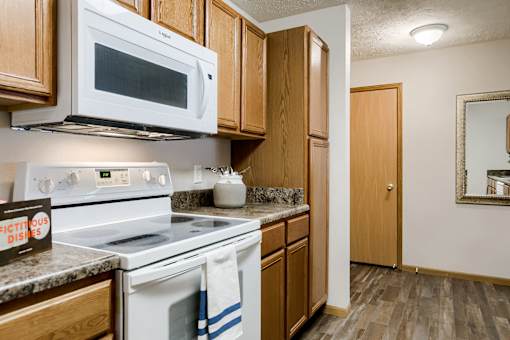 A kitchen with a white oven and microwave above it.