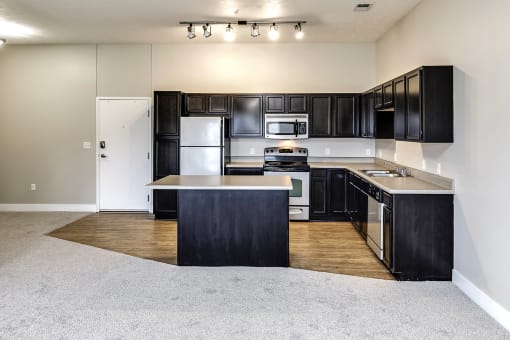 Kitchen with black cabinets and stainless steel appliances at Tamarin Ridge in Lincoln, NE