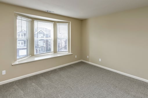 Bedroom with large windows at The Vue Apartments, Bellevue
