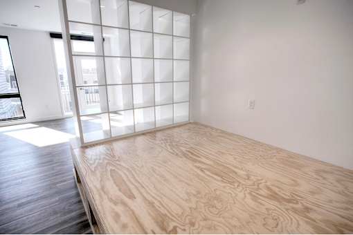 A room with a wooden floor and a large window with a grid of panes.
