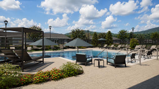 A pool area with sun loungers and umbrellas.