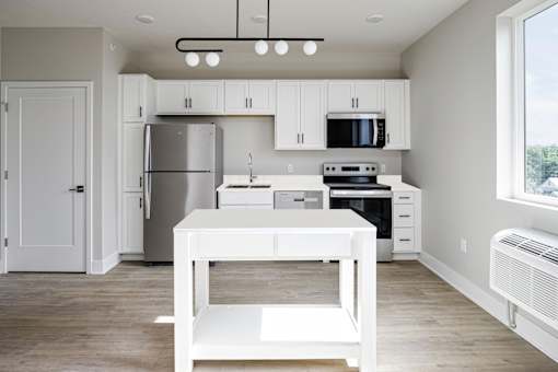 A white kitchen with a table and chairs.