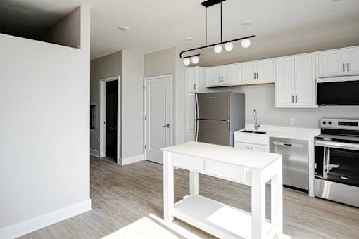 A modern kitchen with white cabinets and stainless steel appliances.