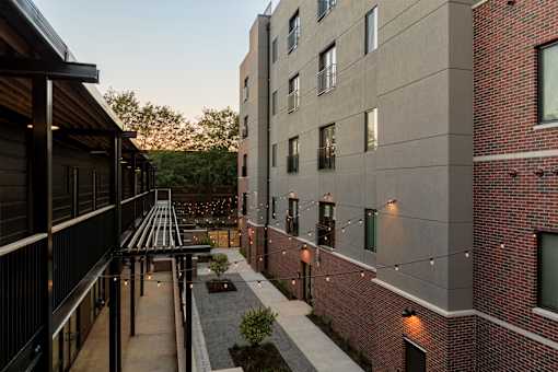 A modern building with a balcony and a small garden.