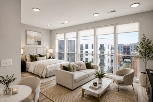A well-lit, modern bedroom with a large bed and a view of the city.