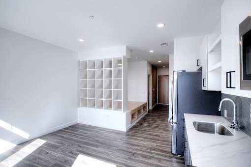 A modern kitchen with a grey floor and white walls.