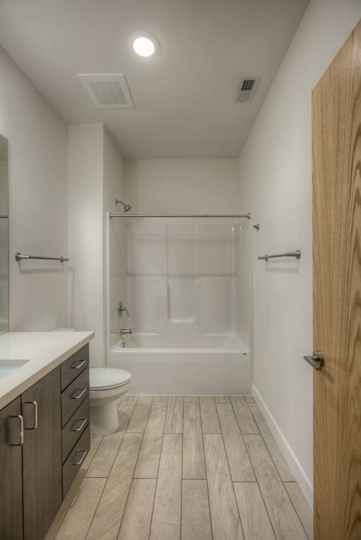 A white bathroom with a wooden door.