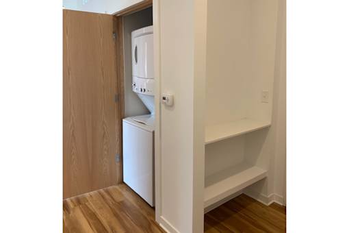A white dishwasher is built into a wooden cabinet.