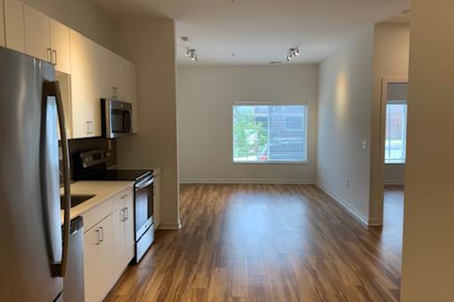 A kitchen with a refrigerator, microwave, and oven.