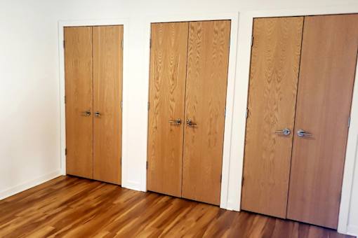 Three brown wooden doors in a row.