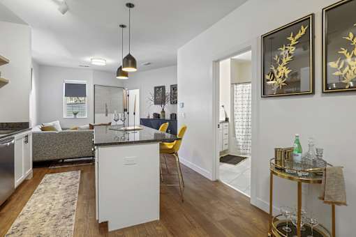 A modern kitchen with a white island and yellow chairs.