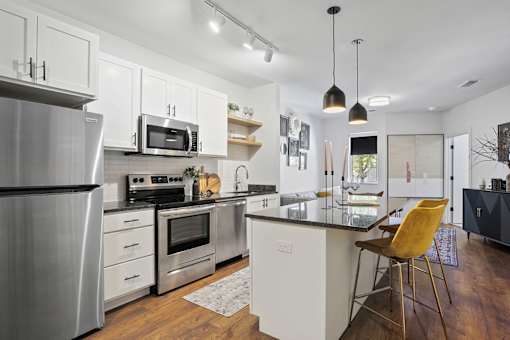 A modern kitchen with a refrigerator, oven, and microwave.