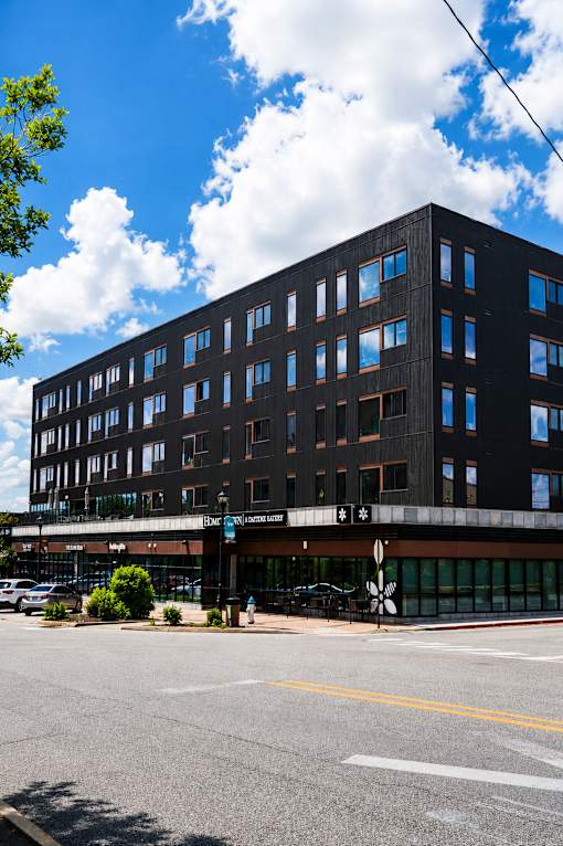 A black building with a parking lot in front of it.