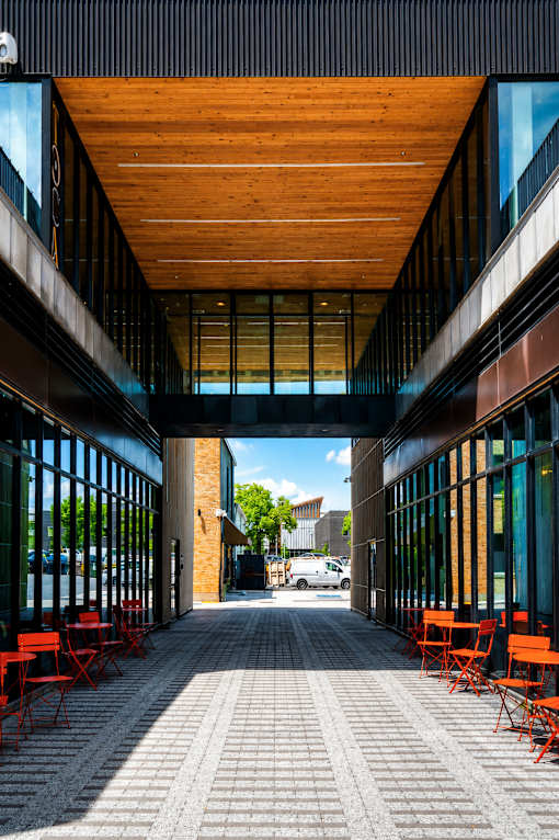 A long hallway with a wooden ceiling and brick flooring.