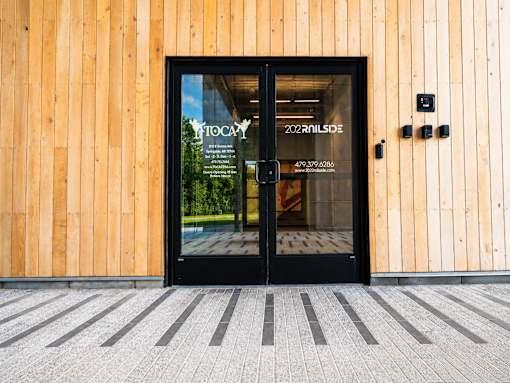 The entrance to a building with a glass door and a sign that reads "FROG".