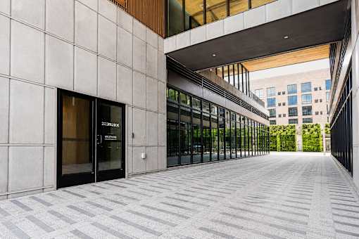 A modern building with a glass entrance and a tiled walkway.