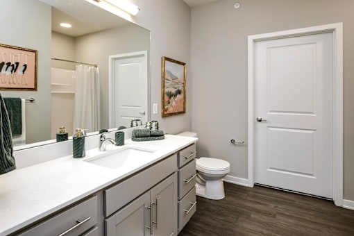 A bathroom with a white sink, toilet, and a white door.