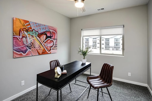 A room with a table and chairs and a painting on the wall.