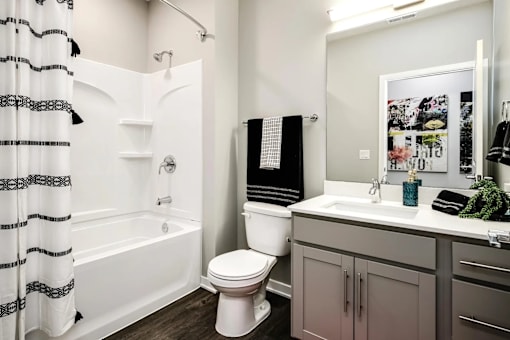 A white toilet sits next to a white sink in a bathroom.