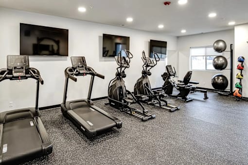 A gym with treadmills, exercise bikes, and other equipment.