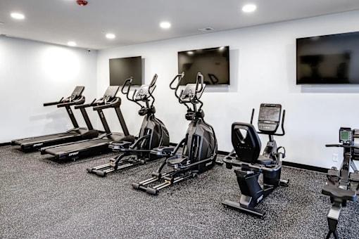 A gym with treadmills, exercise bikes, and elliptical machines.