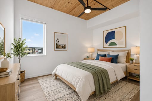 A bedroom with a bed, nightstands, and a ceiling fan.