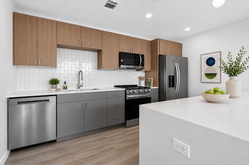 A modern kitchen with stainless steel appliances and wooden cabinets.