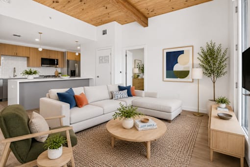 A living room with a white couch and a wooden coffee table.