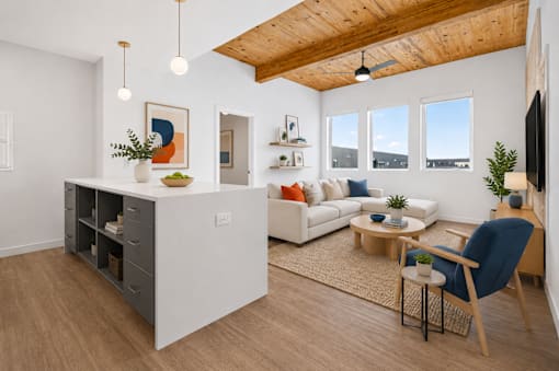 A living room with a white couch, a wooden coffee table, and a blue chair.