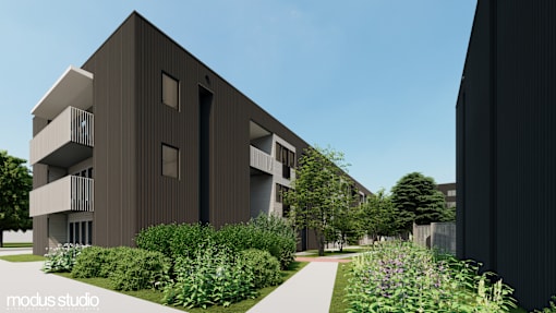 A modern building with a balcony and a garden in front.