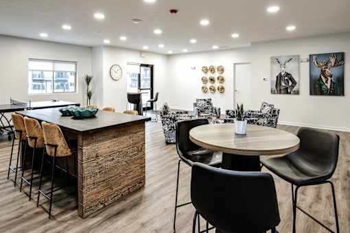 VUE 19 (Clubhouse) - Modern dining area with a wooden bar and chairs.