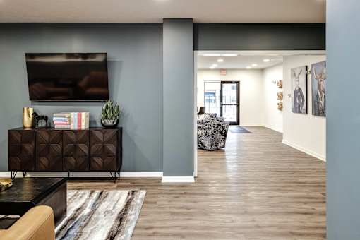VUE 19 (Clubhouse) - Living room with a brown cabinet, a television, and a rug.