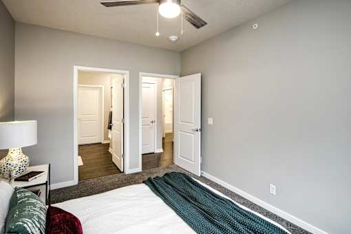 VUE 19 (Model 2Bd) - Bedroom with a bed, a lamp, and a rug.