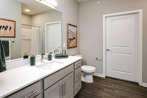 VUE 19 (Model 2Bd) -Bathroom with a white sink, toilet, and a white door.