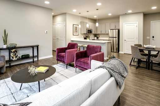 VUE 19 (Model 2Bd) - Modern living room with a white sofa and a black coffee table.