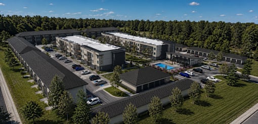 A large building complex with a parking lot in front.