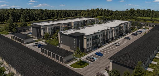 A modern building complex with a parking lot in front.