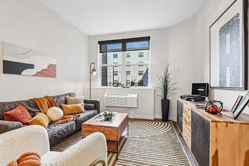 A living room with a grey couch and a wooden coffee table.