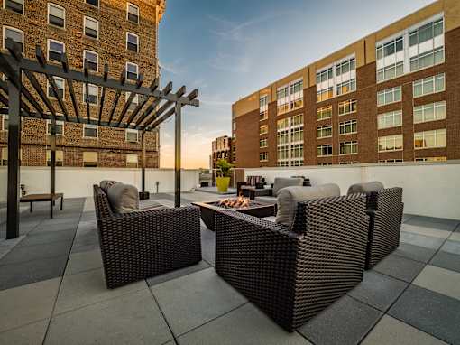 a patio with chairs and a fire pit