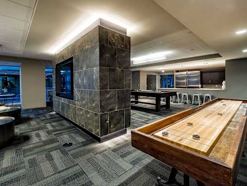 a game room with a shuffleboard table and a pool table