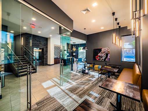 A modern lobby with a glass wall and a staircase.