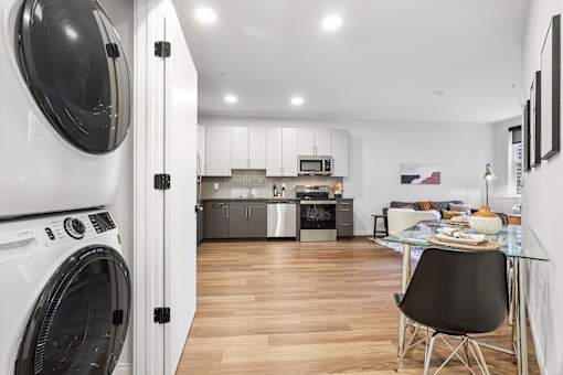 A modern kitchen with a washing machine in the foreground.