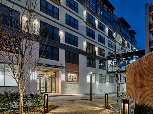 an apartment building at night with a sidewalk and benches at 520 Lofts, Allentown