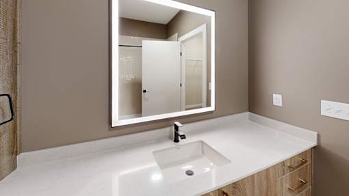 Modern bathroom vanity with backlit mirror at The Confluence Apartments, Pennsylvania