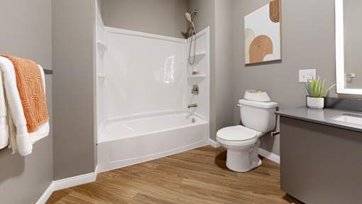 A white toilet sits next to a white bathtub in a bathroom.