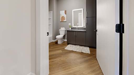 A bathroom with a toilet, sink, and mirror.