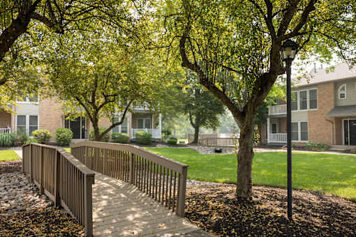 A tree-lined walkway leads to a building. at Brookfield Apartments, Macungie, PA