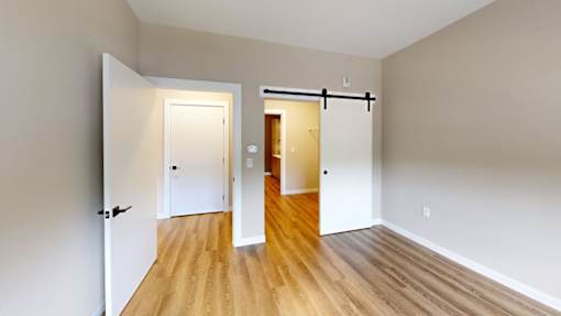 Open floor plan with barn door and hardwood flooring at The Confluence Apartments, Easton, PA 18042